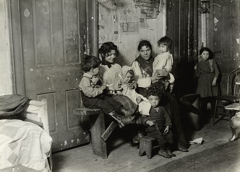 An Italian family sits for its portrait in Chicago tenement near Hull House, 1910